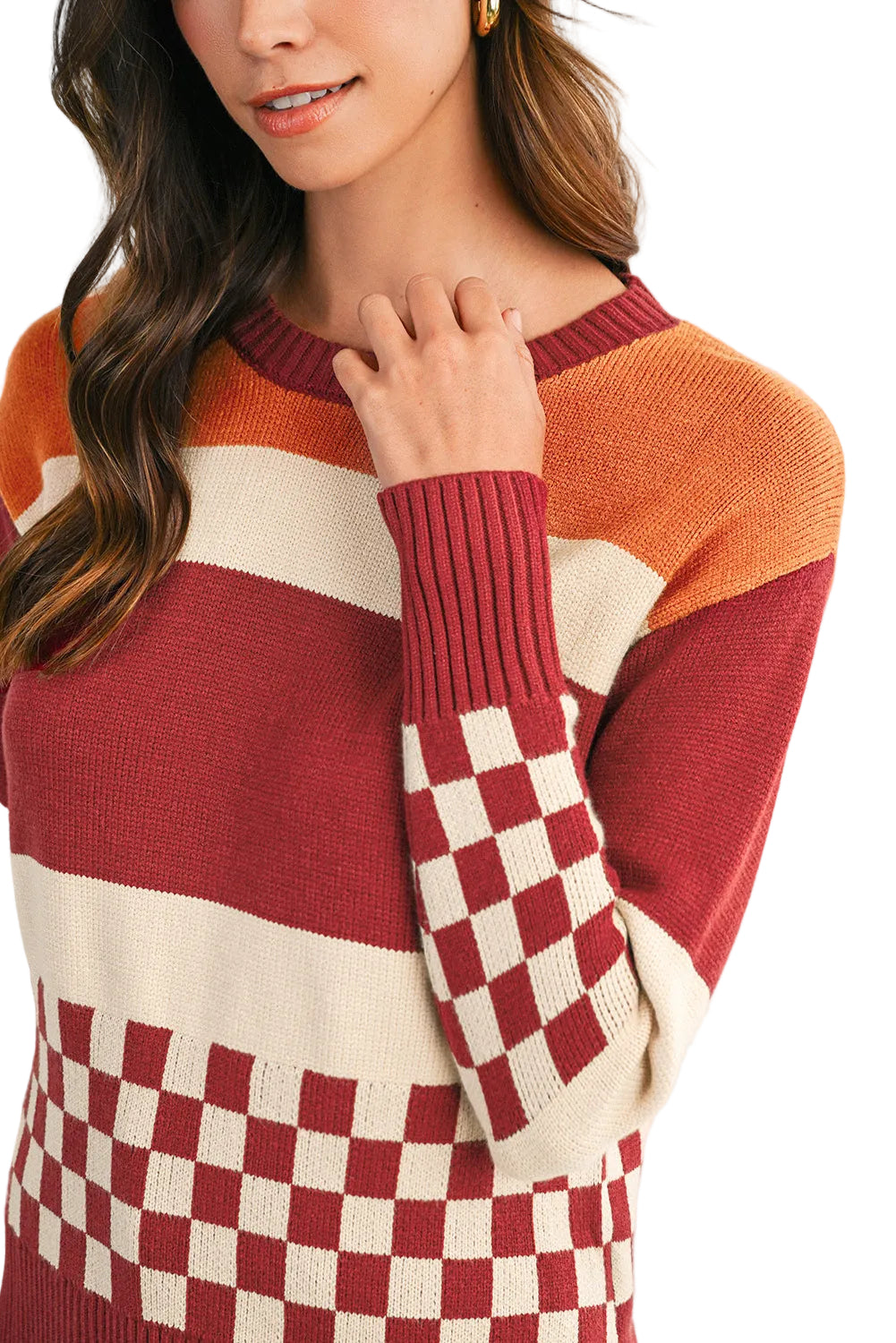 Person wearing a colorful striped sweater with a checkered pattern on a plain background