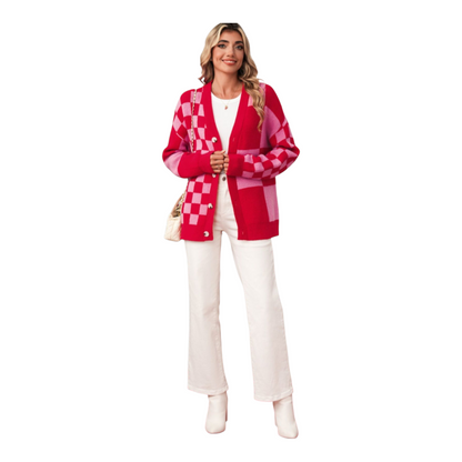 Woman wearing a red and pink checkered cardigan with white pants on a white background