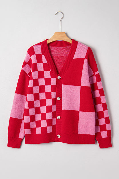 Red and pink checkered cardigan on a hanger against a white background