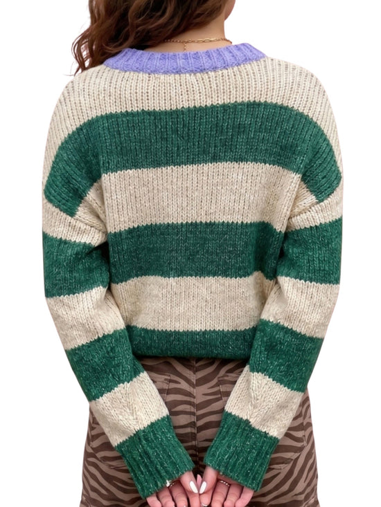 A person shown from the back wearing a chunky knit sweater with wide horizontal stripes in dark green and cream, featuring a light purple ribbed crew neck.