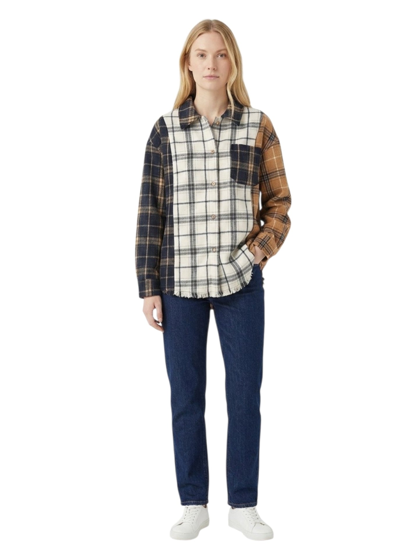 A woman modeling a long-sleeve plaid button-up shirt with a cream, black, and brown checkered body and dark navy plaid sleeves, paired with dark blue jeans and white sneakers on a white background.