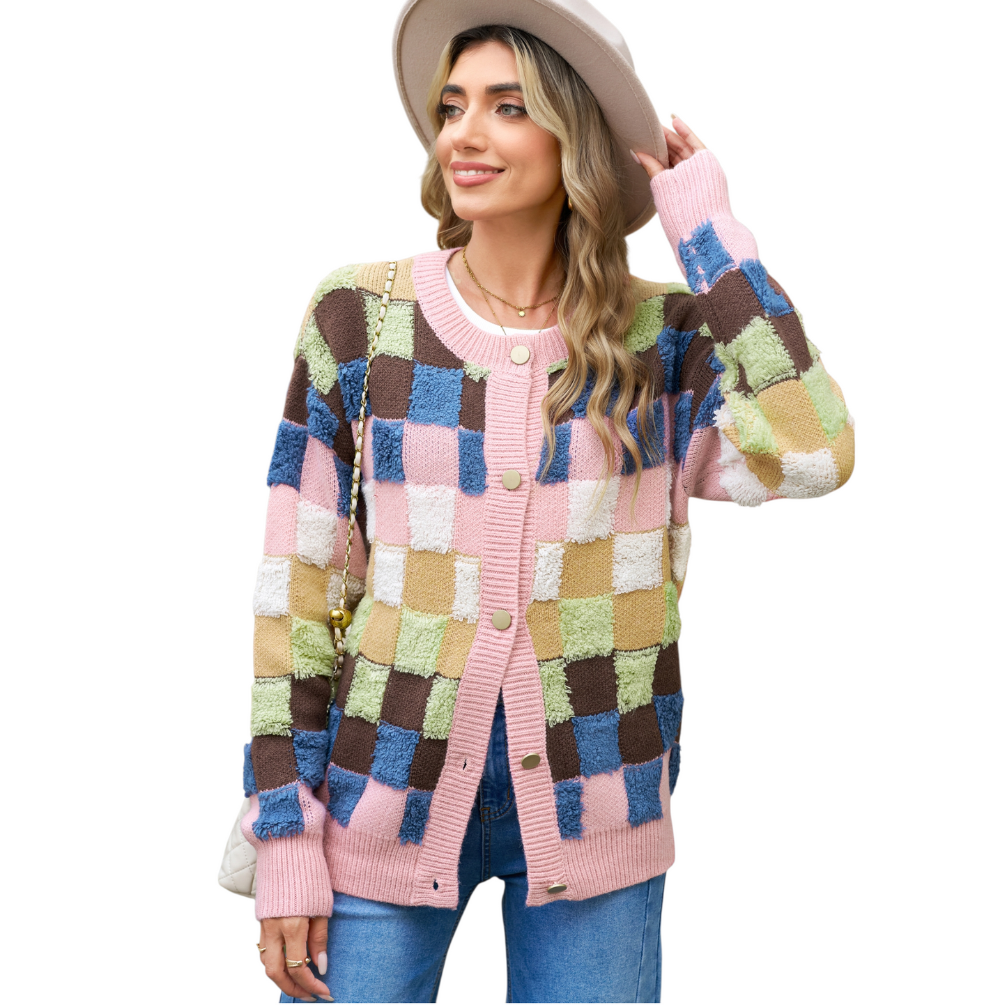 A woman wearing a modern colourblock plaid cardigan featuring textured pink, blue, brown, and olive green squares with gold-toned buttons.