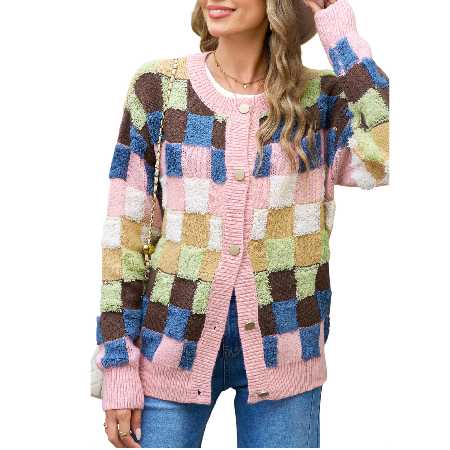 A woman wearing a modern colourblock plaid cardigan featuring textured pink, blue, brown, and olive green squares with gold-toned buttons.