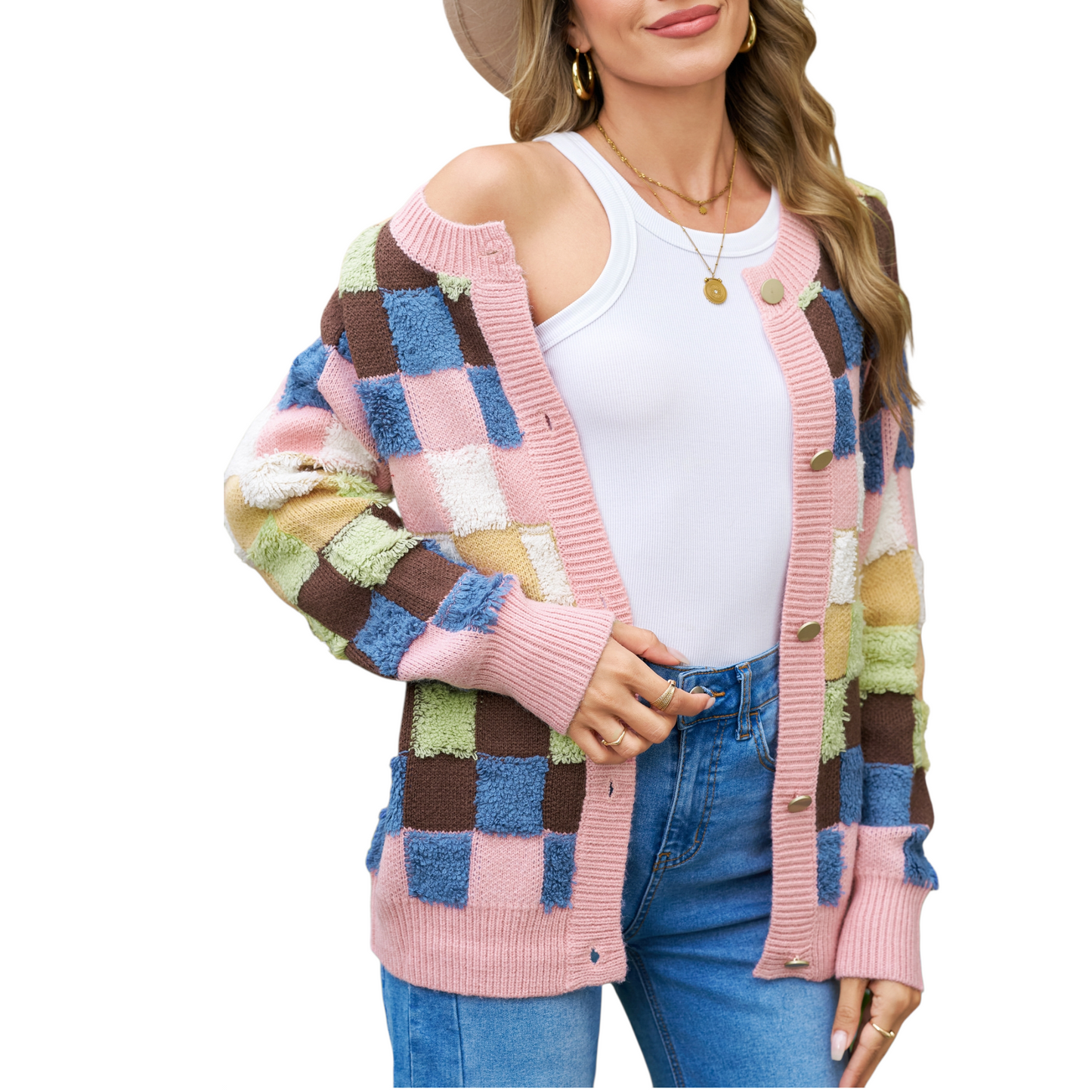 A woman wearing a modern colourblock plaid cardigan featuring textured pink, blue, brown, and olive green squares with gold-toned buttons.