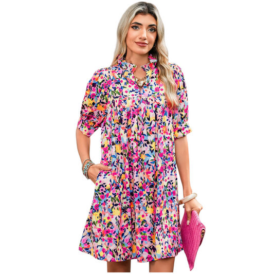 A woman wearing a lilac floral smocked maxi dress featuring a square neckline, short puff sleeves, and a tiered skirt with an all-over purple botanical print.