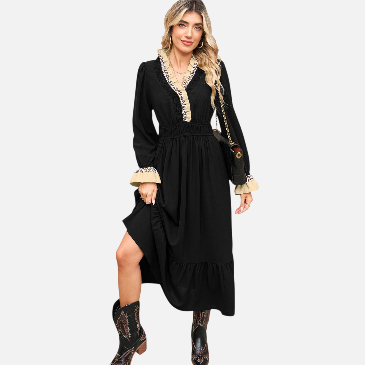 Full-length view of a model wearing a black tiered midi dress with animal print collar and cuff details, styled with cowboy boots.