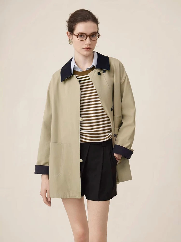 Person wearing a beige coat, striped shirt, and black shorts on a beige background
