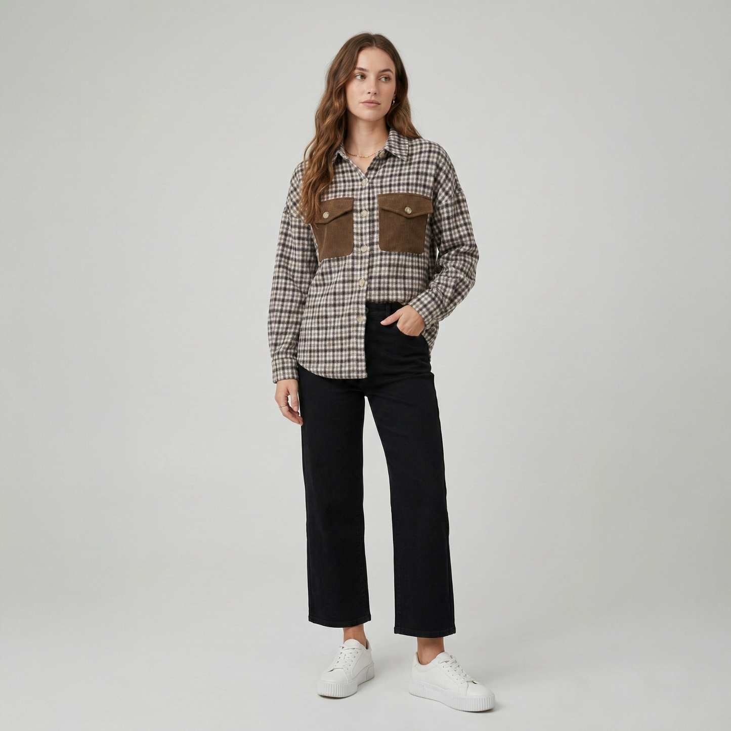 Front view of a model in a textured brown, tan, and beige patchwork shacket with a relaxed fit.