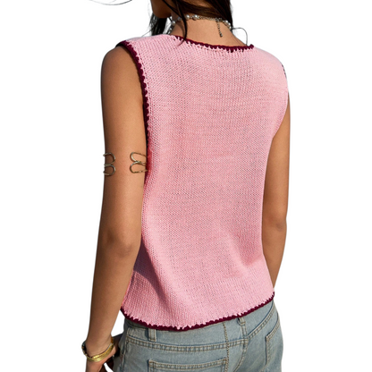 Pink knitted vest worn by a person on a white background