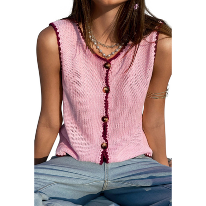 Pink knitted vest with buttons worn by a person on a white background