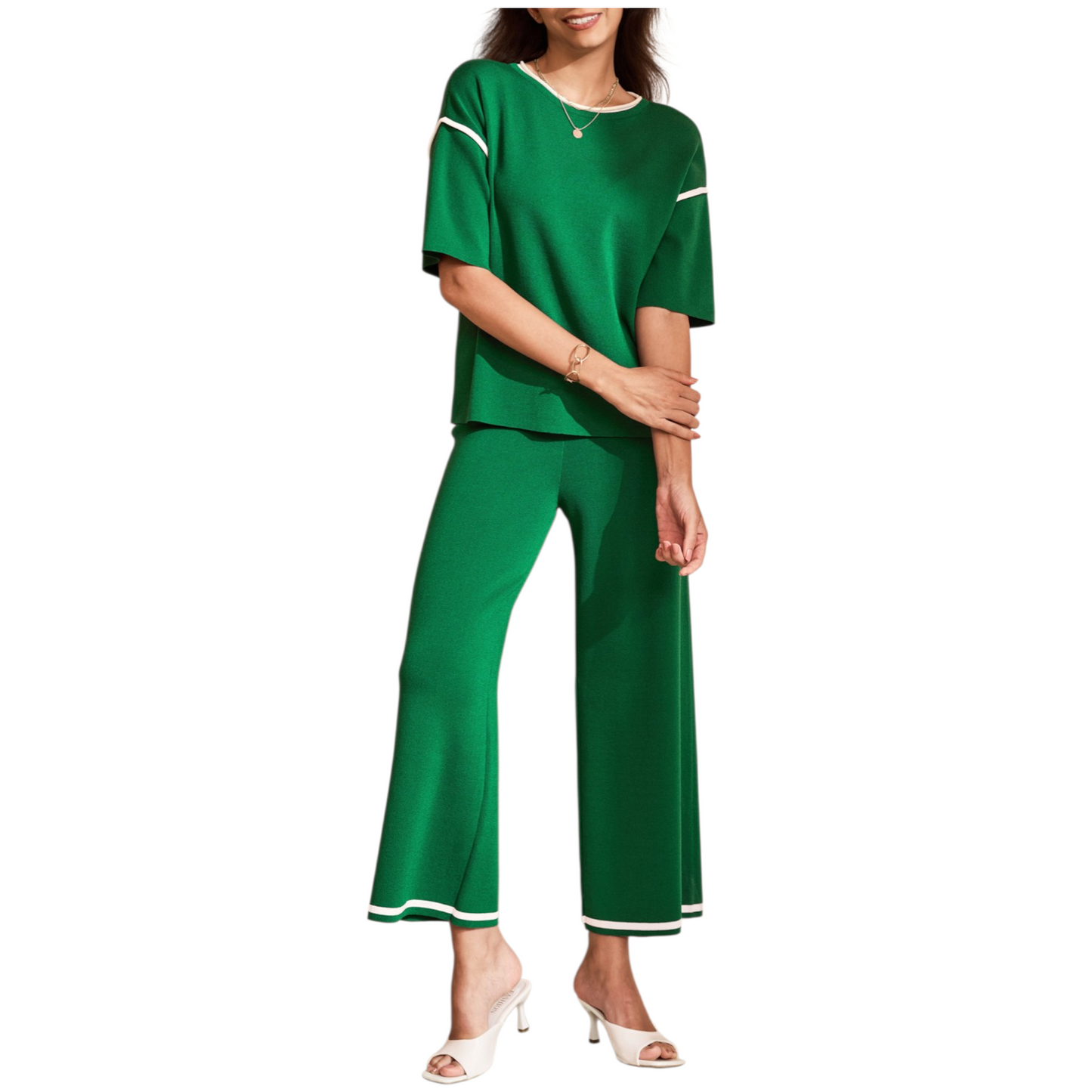 A woman wearing a green two-piece knit loungewear set featuring a half-sleeve top with contrast trim and matching high-waisted wide-leg pants.