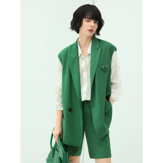 Person wearing a green vest over a white shirt with a white background