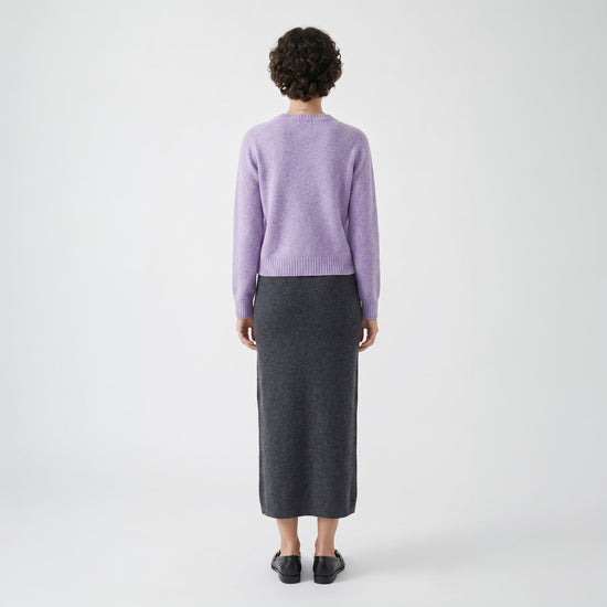 Rear full-length view of the lavender knit jumper highlighting its clean drape and ribbed hemline.