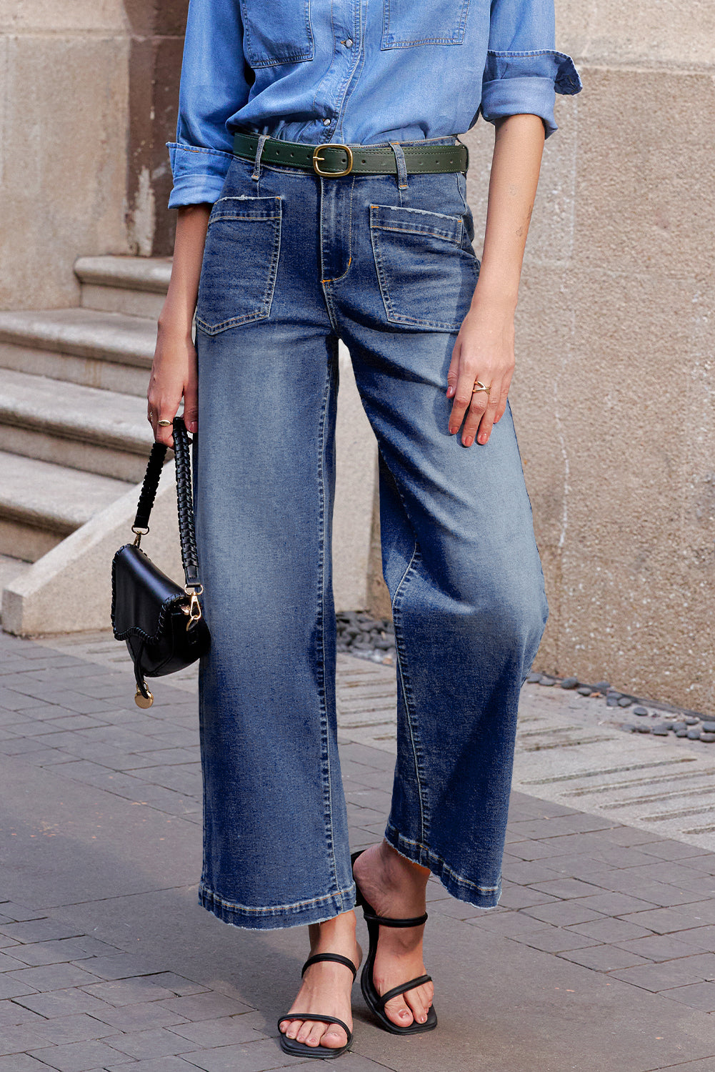 Person wearing blue denim jeans and a matching shirt, standing on a street.