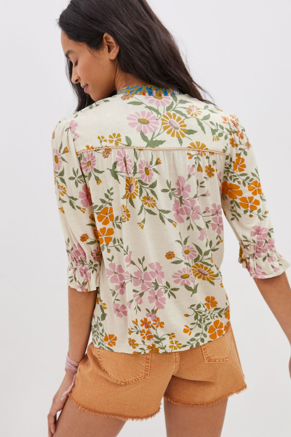 Back view of a model wearing a multicolor boho blouse with a V-neck and half sleeves.