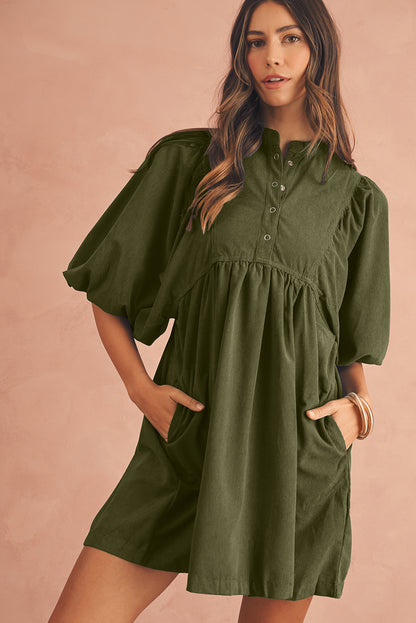 Front view of an olive green babydoll mini dress with puff sleeves on a model , perfect dress for spring occasion.