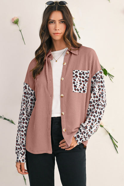 Woman wearing a pink shirt with leopard print sleeves and pocket on a white background