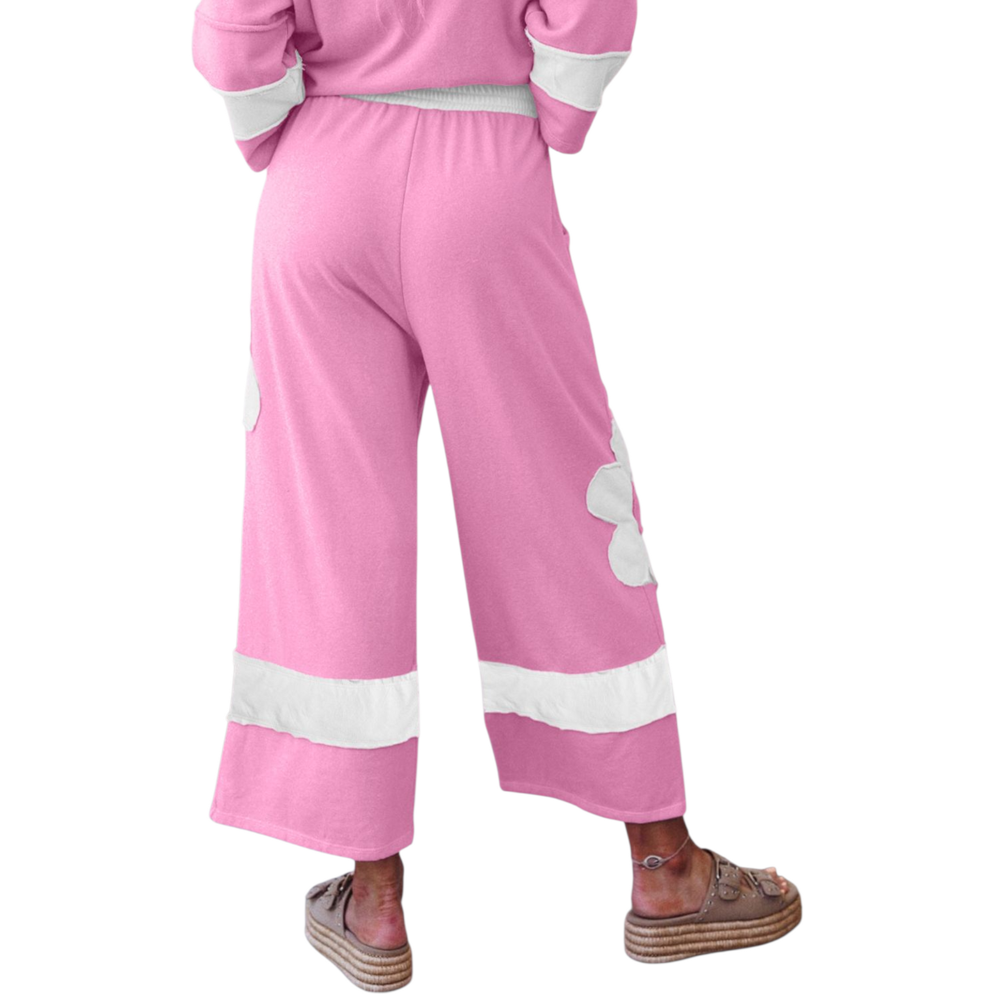 Pink tracksuit with white heart designs on a white background