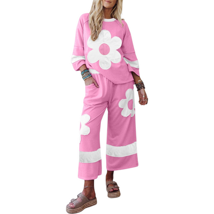 Woman wearing a pink outfit with white flower designs on a white background