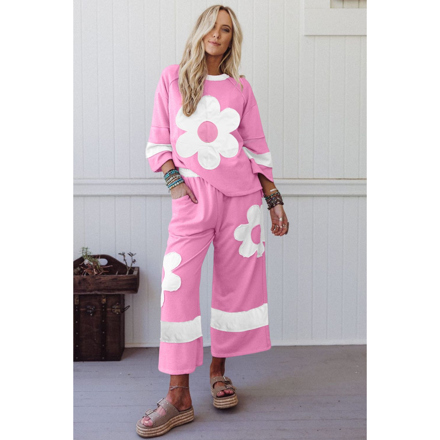 Woman wearing a pink outfit with white flower designs indoors.