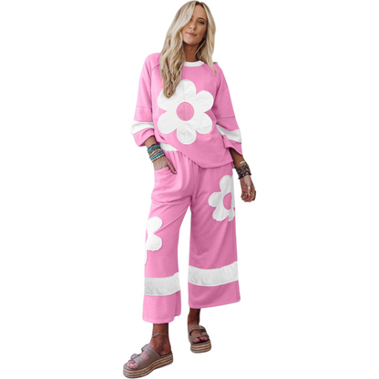 Woman wearing a pink outfit with white flower designs on a white background