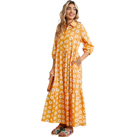 Woman wearing a yellow and white daisy print maxi dress with a collared neckline and button-down front.