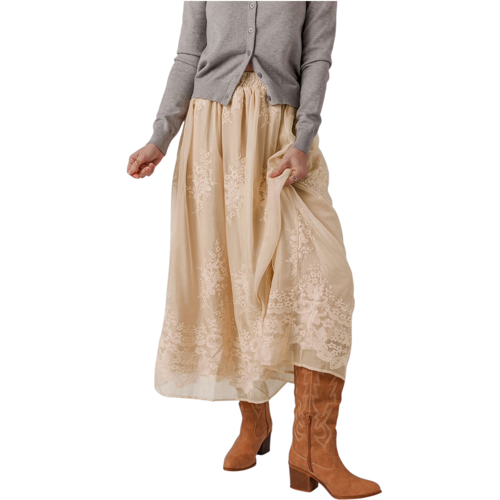 Person wearing a beige lace skirt and brown boots on a white background