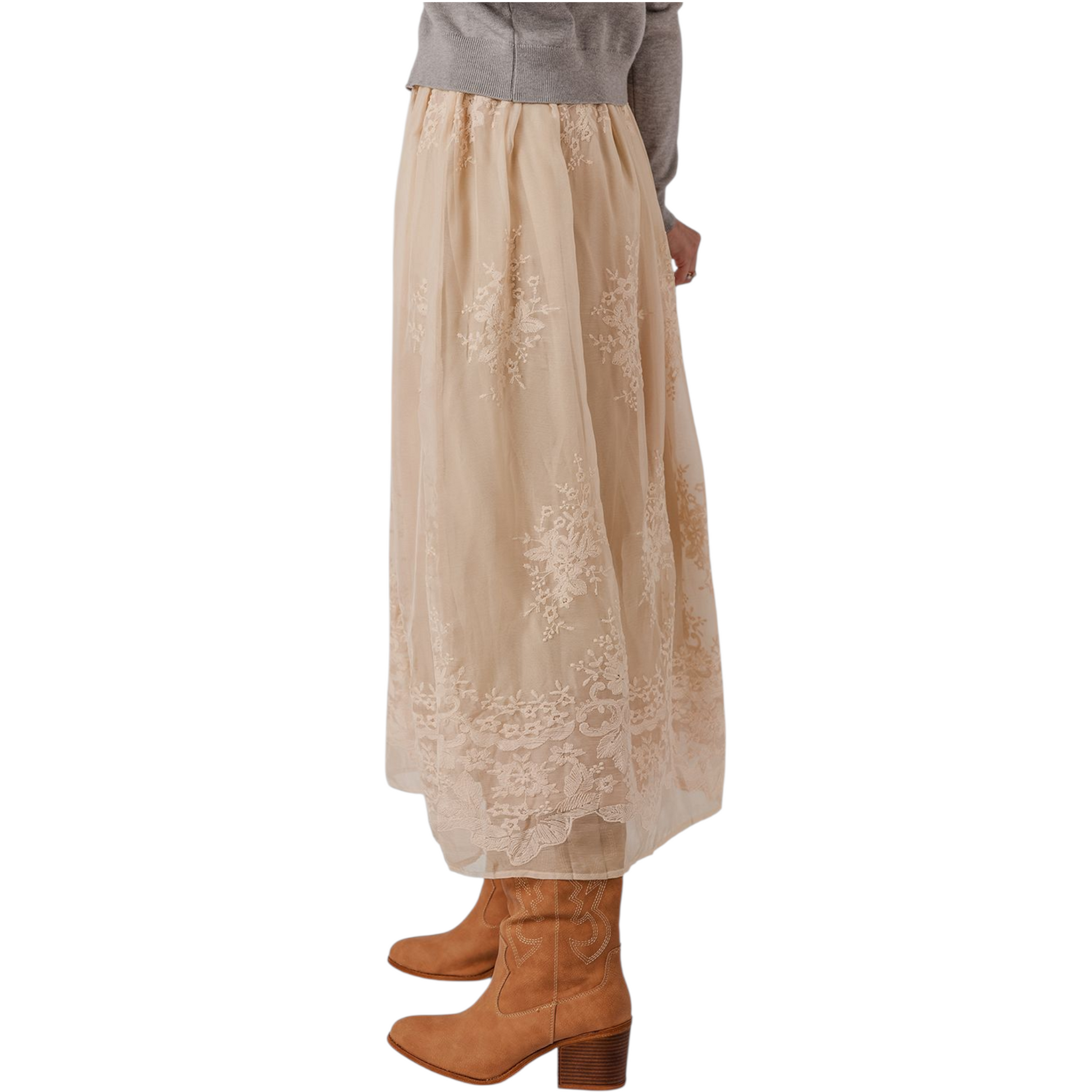 Beige lace skirt worn with brown boots on a white background