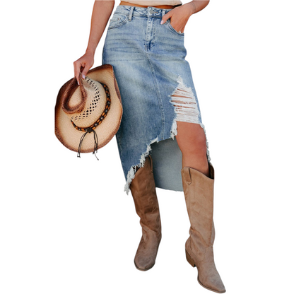 Person wearing a distressed denim skirt and brown knee-high boots, holding a cowboy hat.