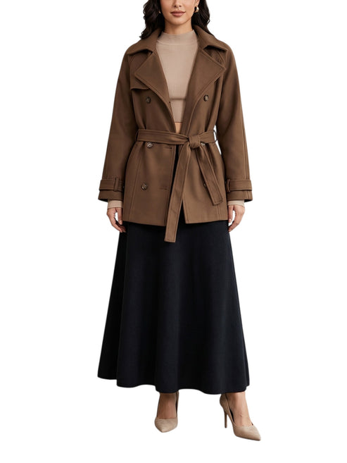 Woman wearing a brown coat with a belt on a white background front view