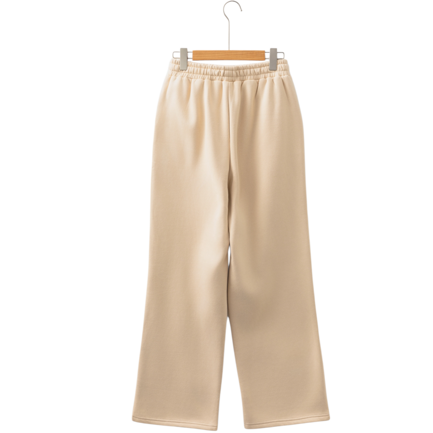 Beige pants hanging on a wooden hanger against a white background