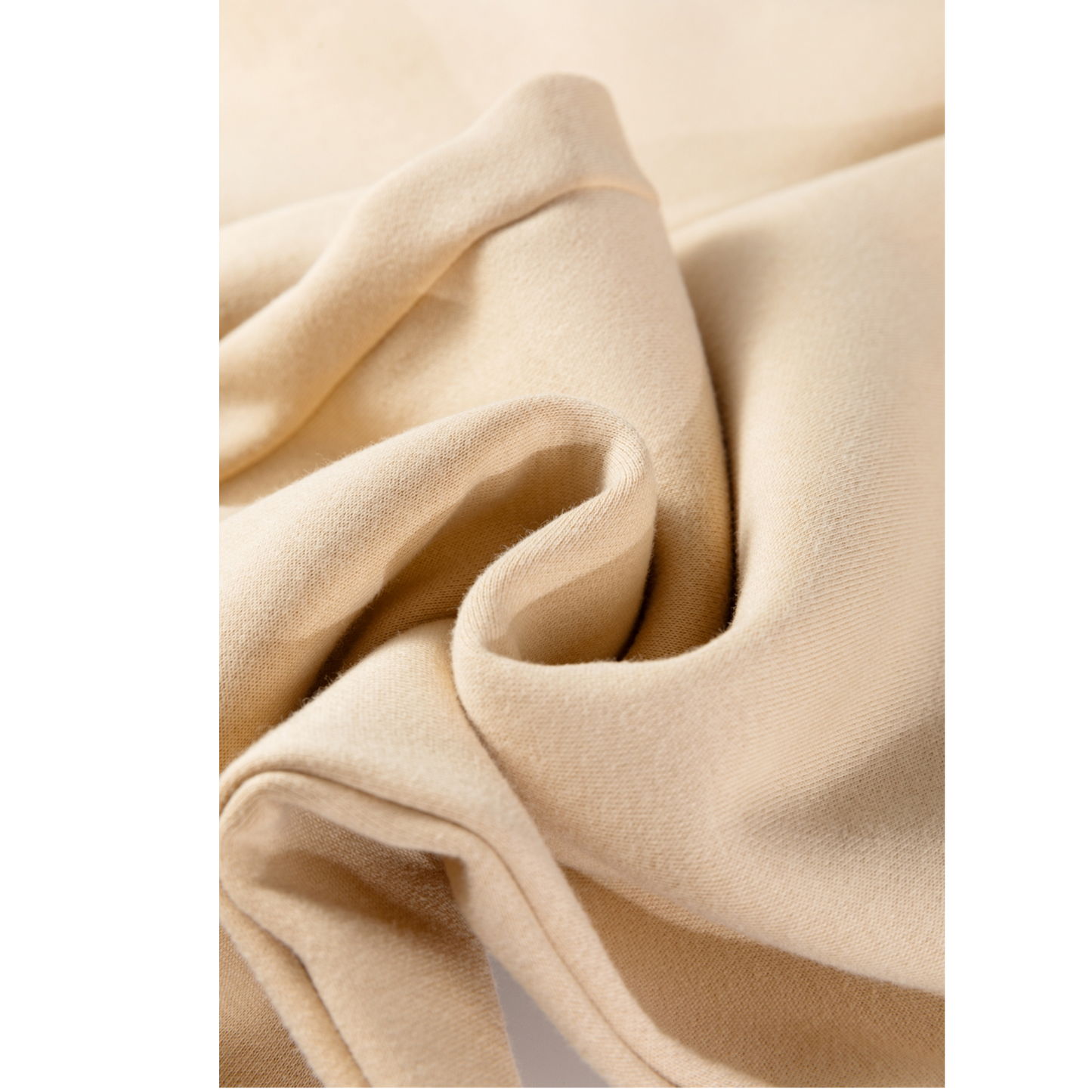 Close-up of beige fabric with folds on a white background