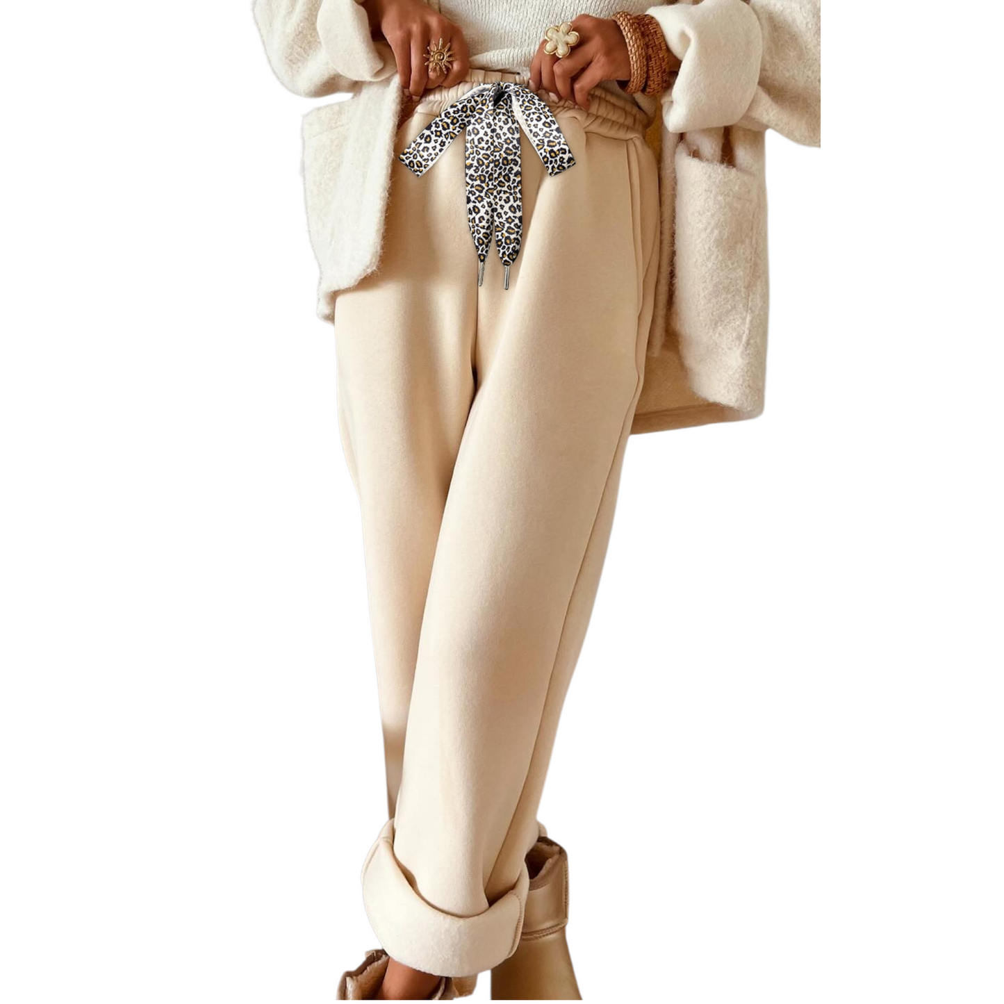 Beige pants with a leopard print bow tie worn by a person on a white background