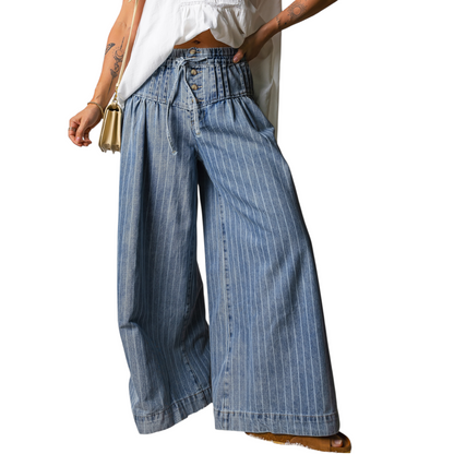 Person wearing blue denim wide-leg pants on a white background