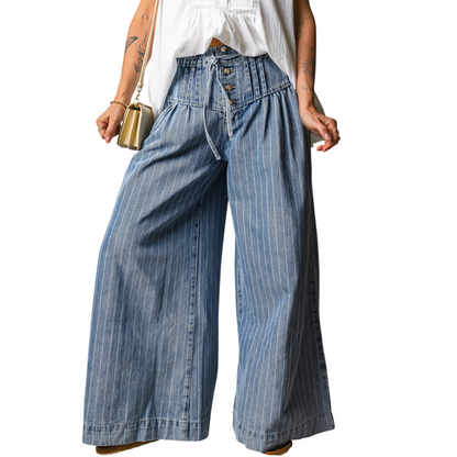 Person wearing wide-leg blue jeans with a white top on a white background