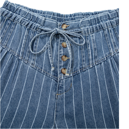 Close-up of blue denim shorts with a drawstring and buttons on a white background