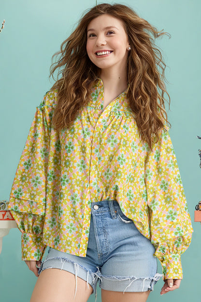 Front view of a green and yellow floral blouse with balloon sleeves paired with denim shorts.