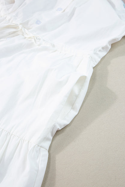 Close-up view of the pocket on a white tiered shirt dress with short sleeves, highlighting the dress's functional design.