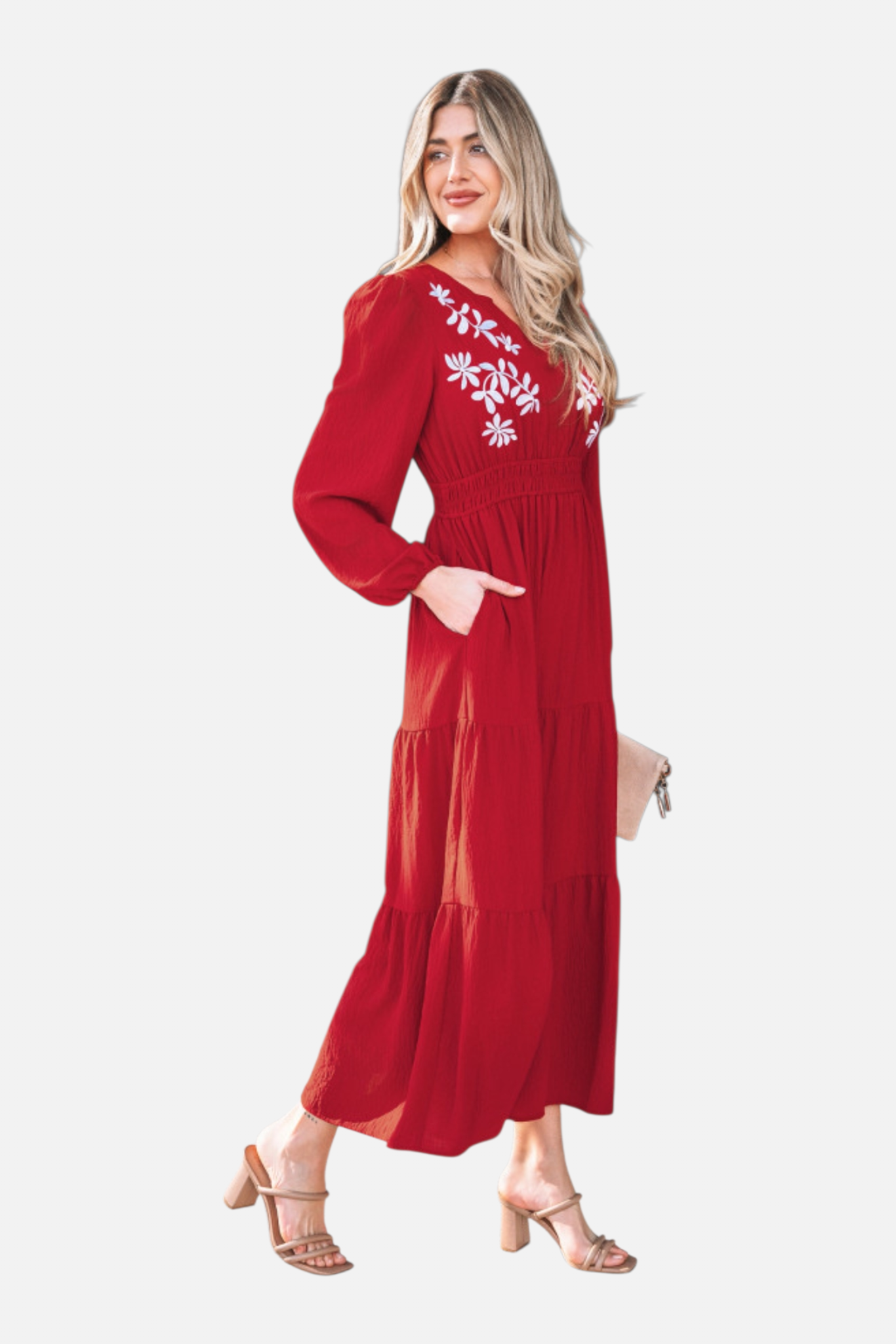 A side profile of the embroidered floral dress highlighting the functional side pockets and the graceful movement of the multi-tier maxi length.