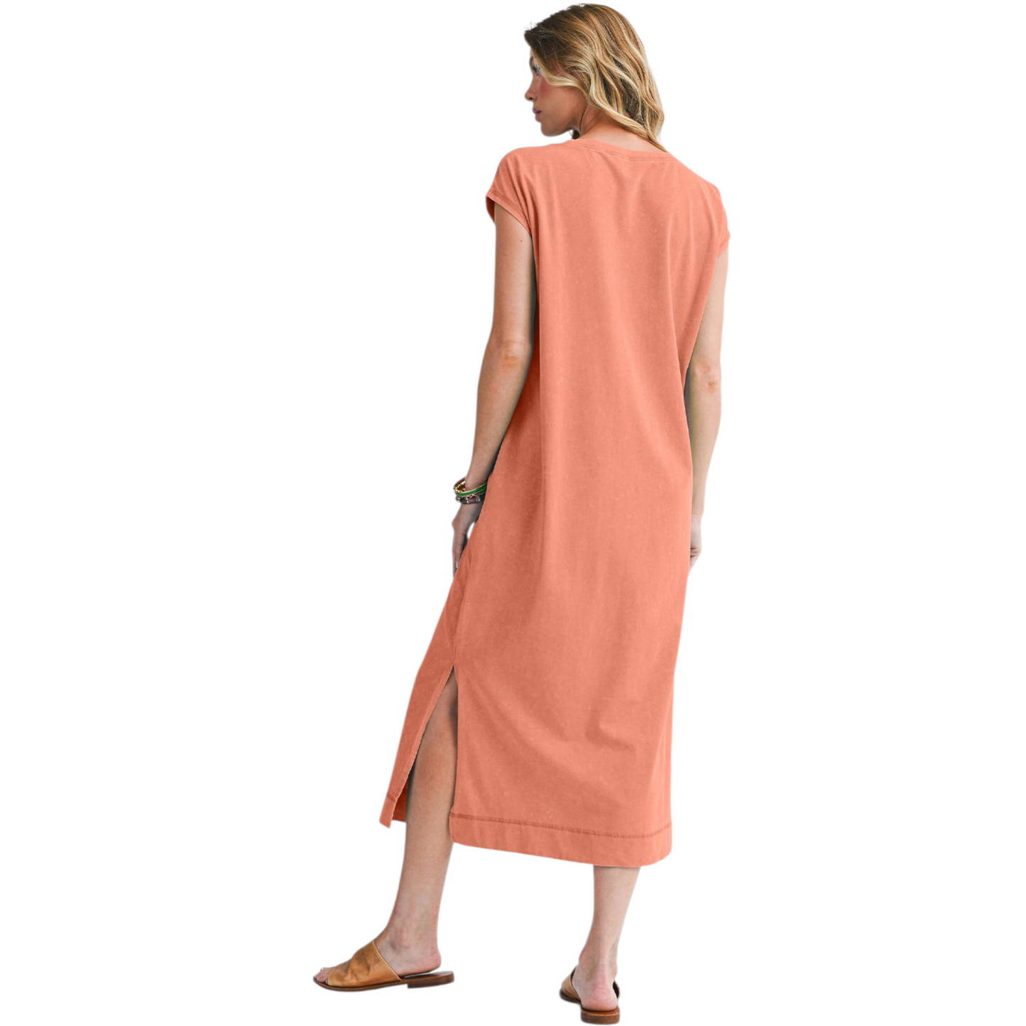 Woman wearing a long peach dress on a white background