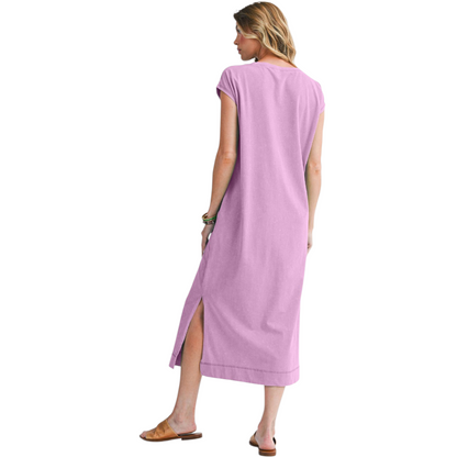 Woman wearing a long pink dress with a slit on a white background