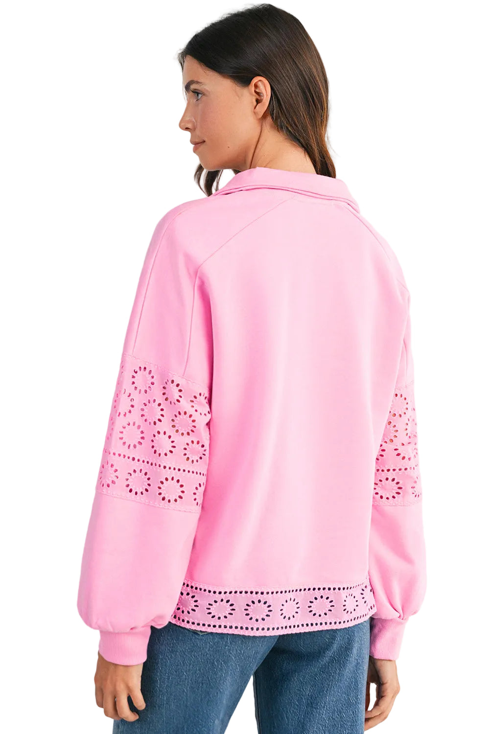 Pink blouse with lace details worn by a person, against a light background 