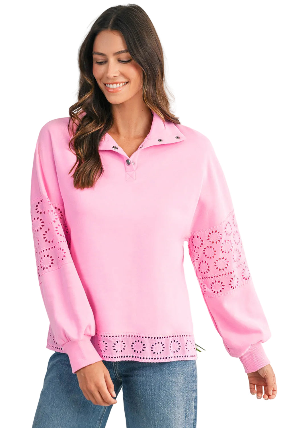 Woman wearing a pink sweater with lace details on a light background