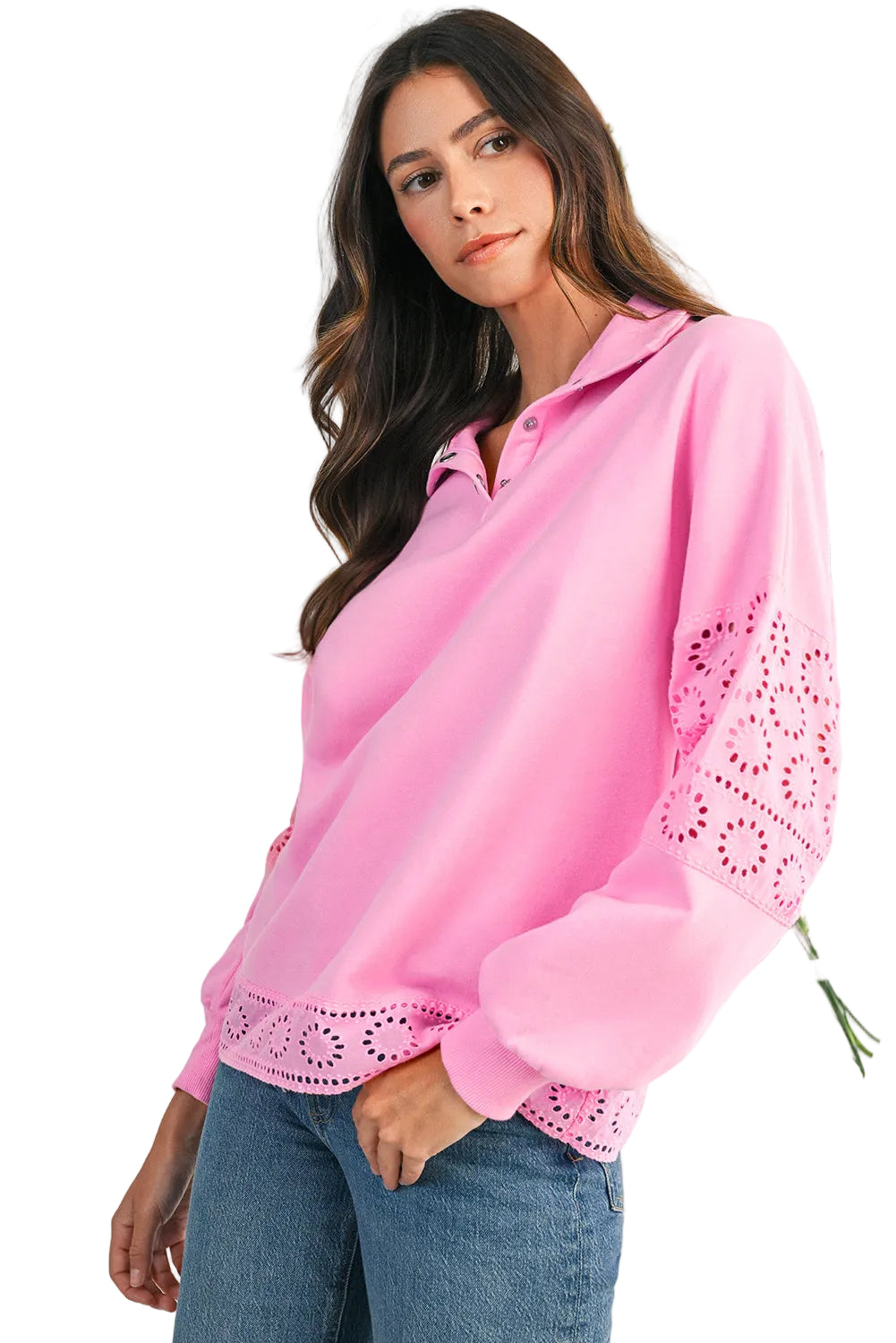 Woman wearing a pink blouse with lace details against a light background with flowers.