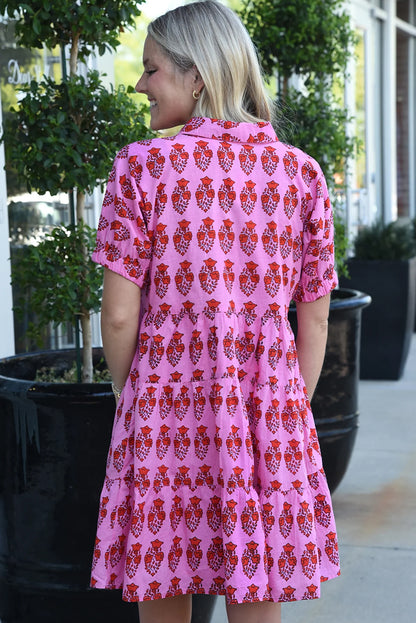 The back side of a pink floral tiered mini dress, featuring short sleeves and a tiered silhouette. Perfect for spring and summer occasions.