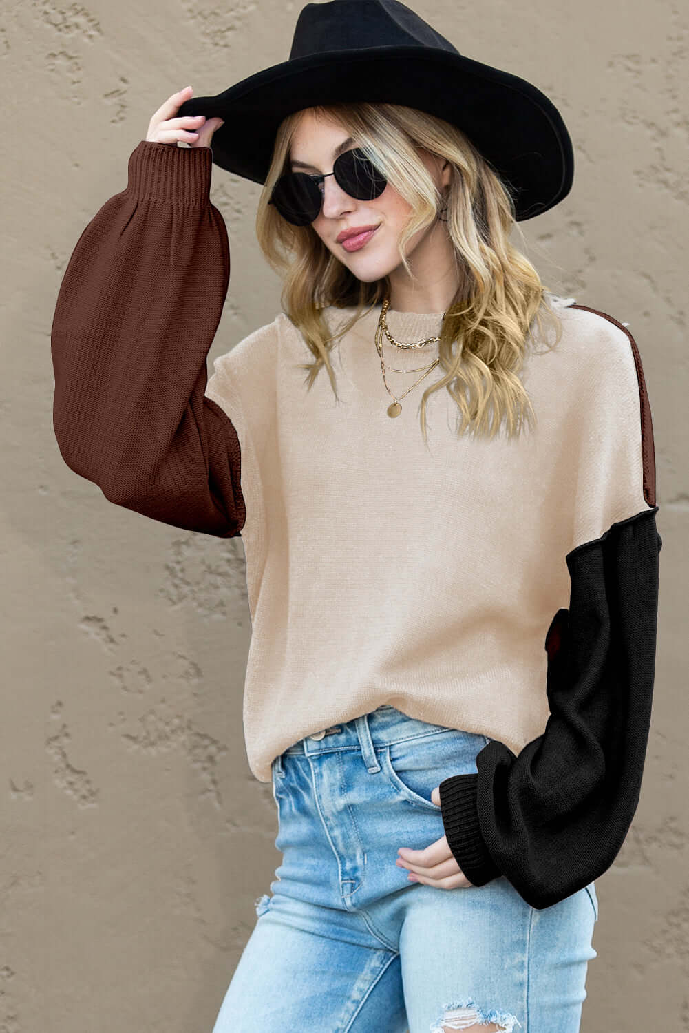 Woman wearing a brown and beige colour block knit jumper, perfect for autumn layering

