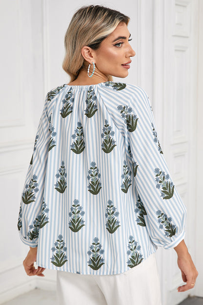 Back view of a blue floral striped blouse with long sleeves, perfect for spring and summer, worn by a model showcasing a boho-chic style.