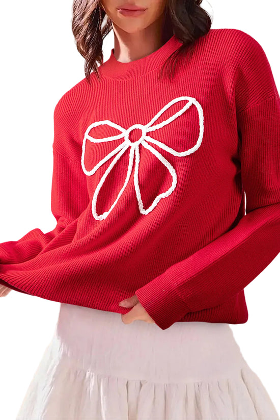 Red sweater with a white bow design worn by a person against a beige background