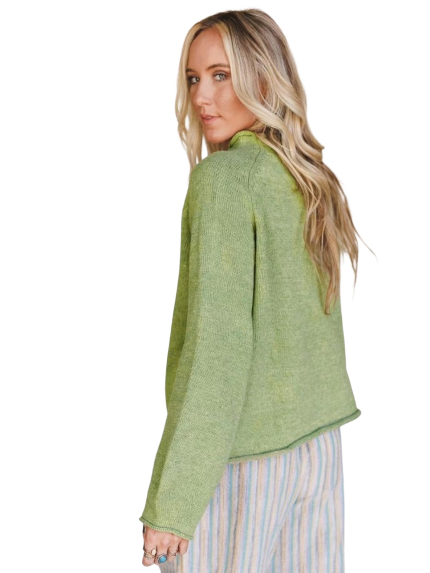 A woman with blonde hair is shown from the back wearing a light green knit cropped cardigan and striped pastel pants against a white background.