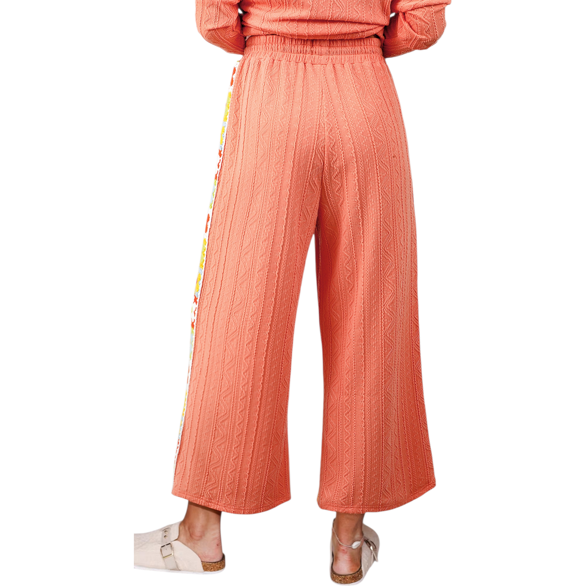 Coral ribbed pants with colorful side panels on a white background
